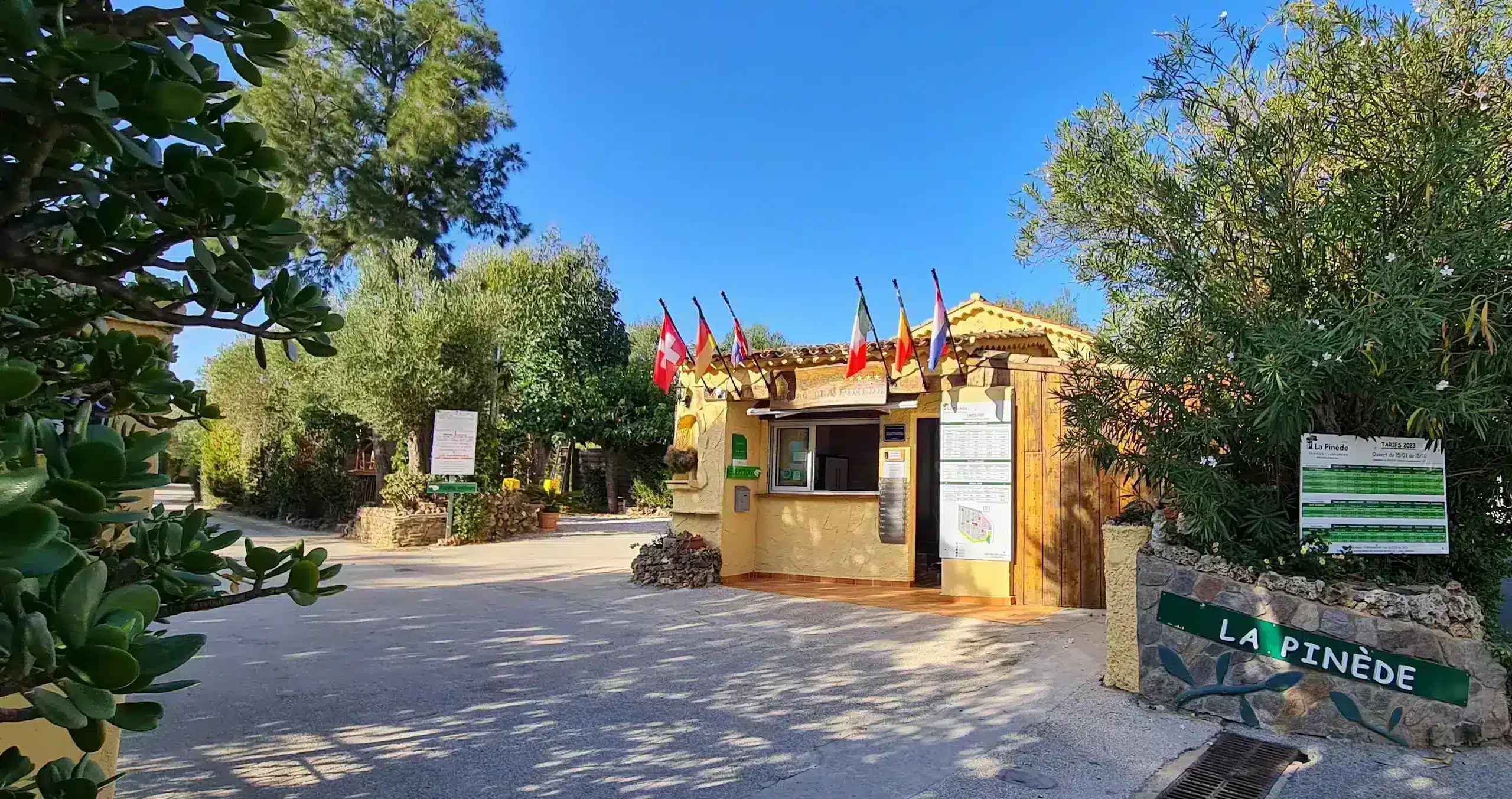 Entrée du camping La Pinède sous ciel bleu