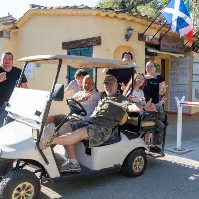 Groupe d’amis posant dans une voiturette de golf