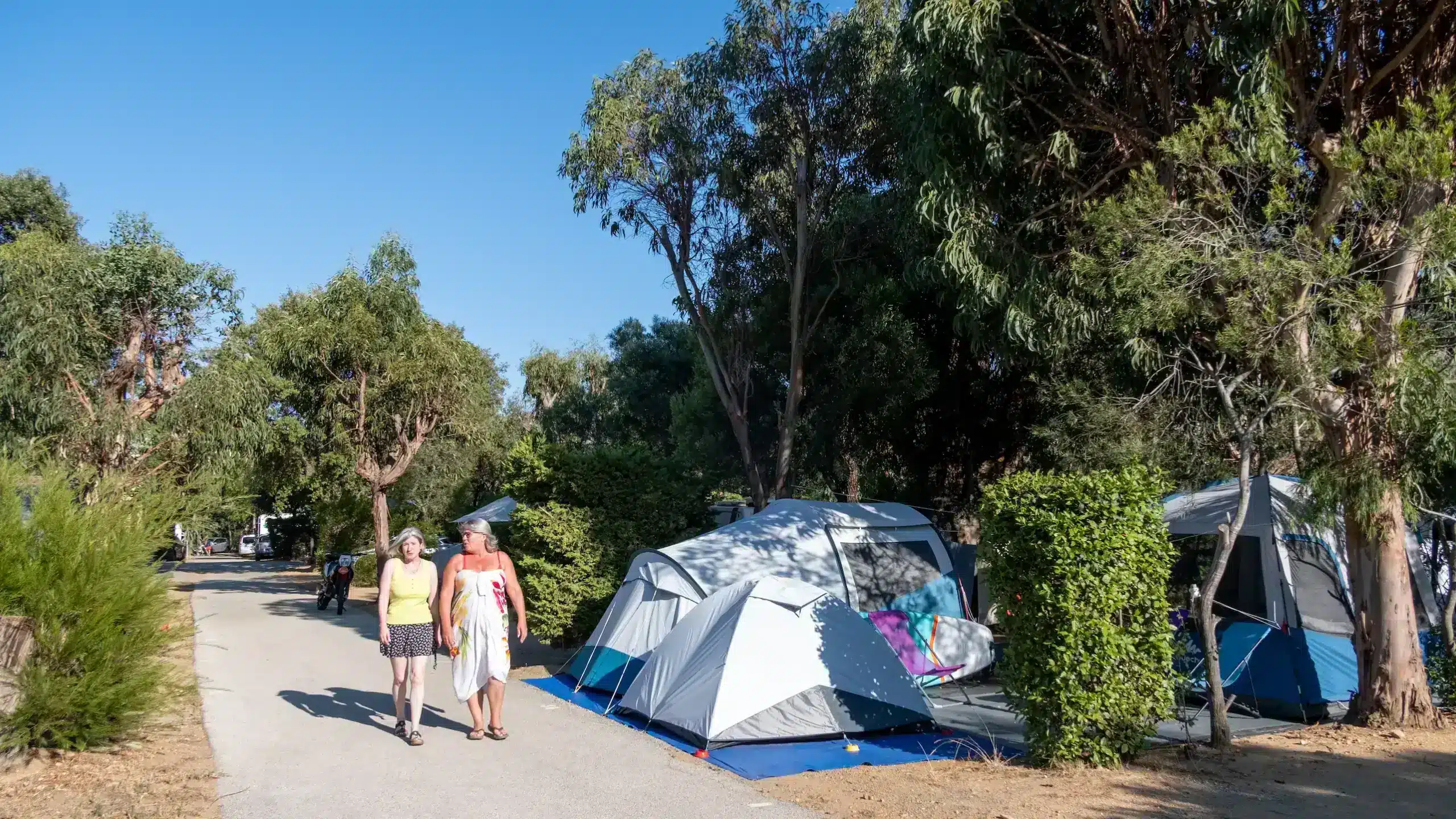 Deux femmes marchant près de tentes en camping