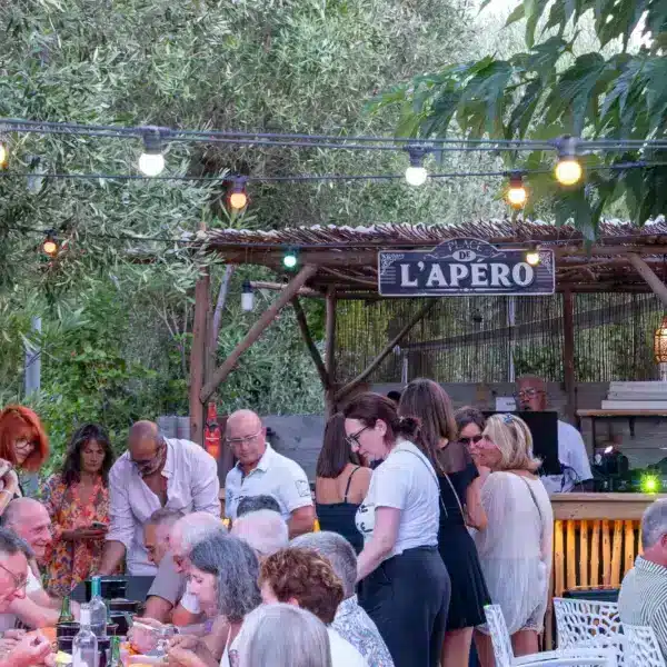 Soirée conviviale au bar extérieur sous guirlandes