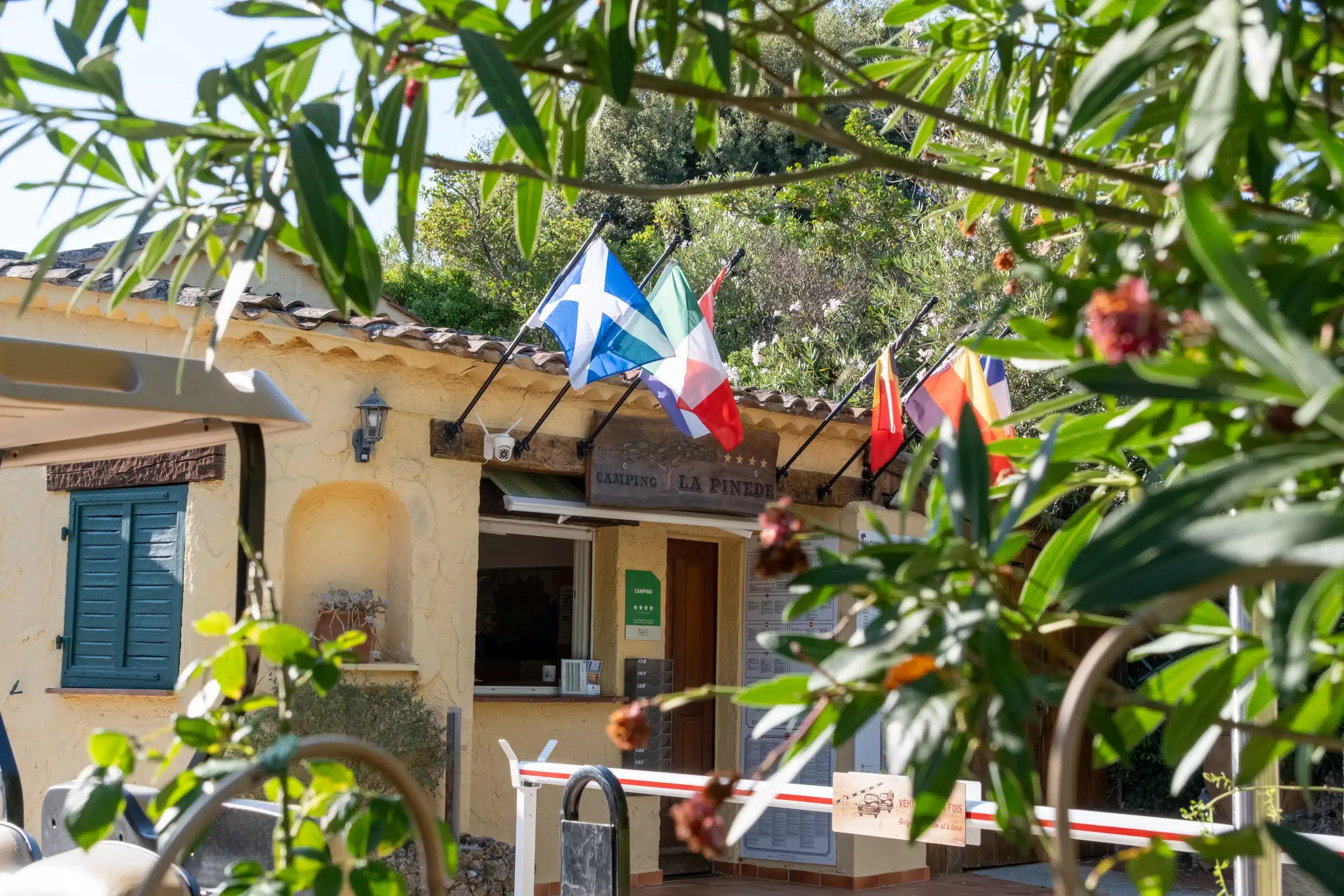 Entrée du camping La Pinède avec drapeaux européens
