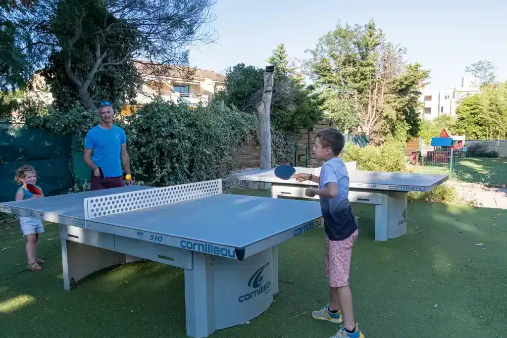 Famille jouant au ping-pong dans un jardin