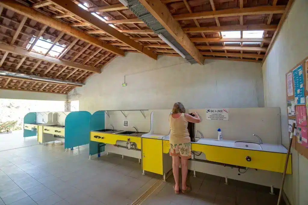 Femme lavant du linge dans un lavoir couvert