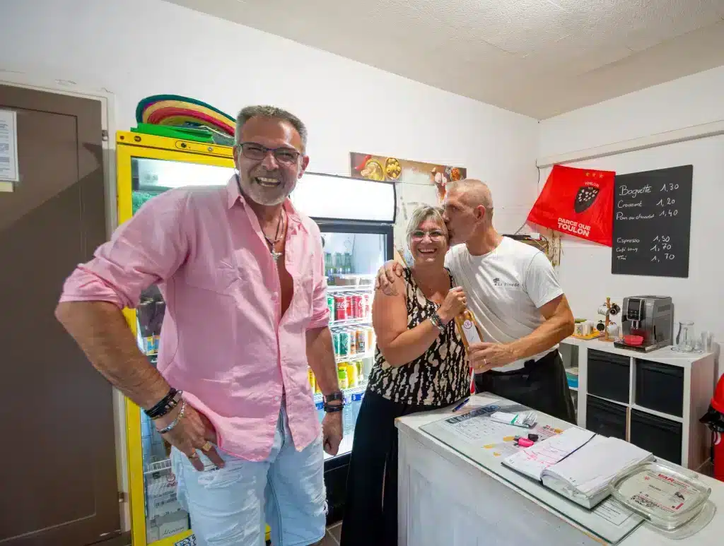 Trois adultes souriants dans un petit café