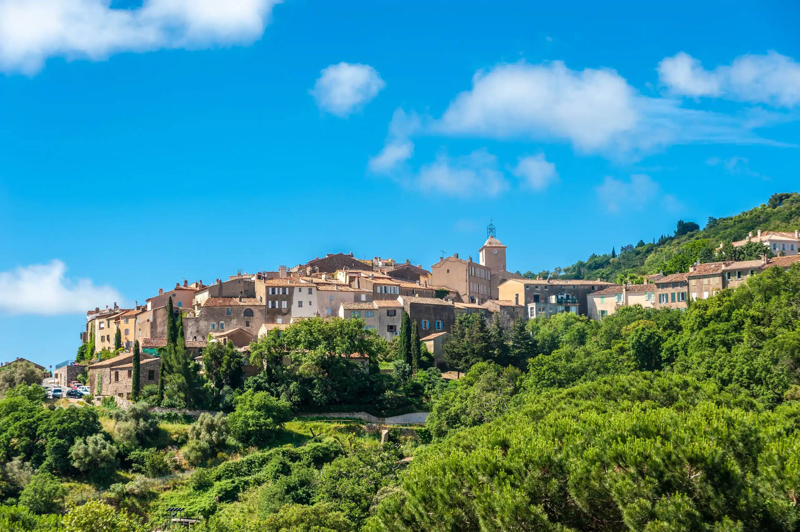 Village perché aux toits ocre sous ciel bleu