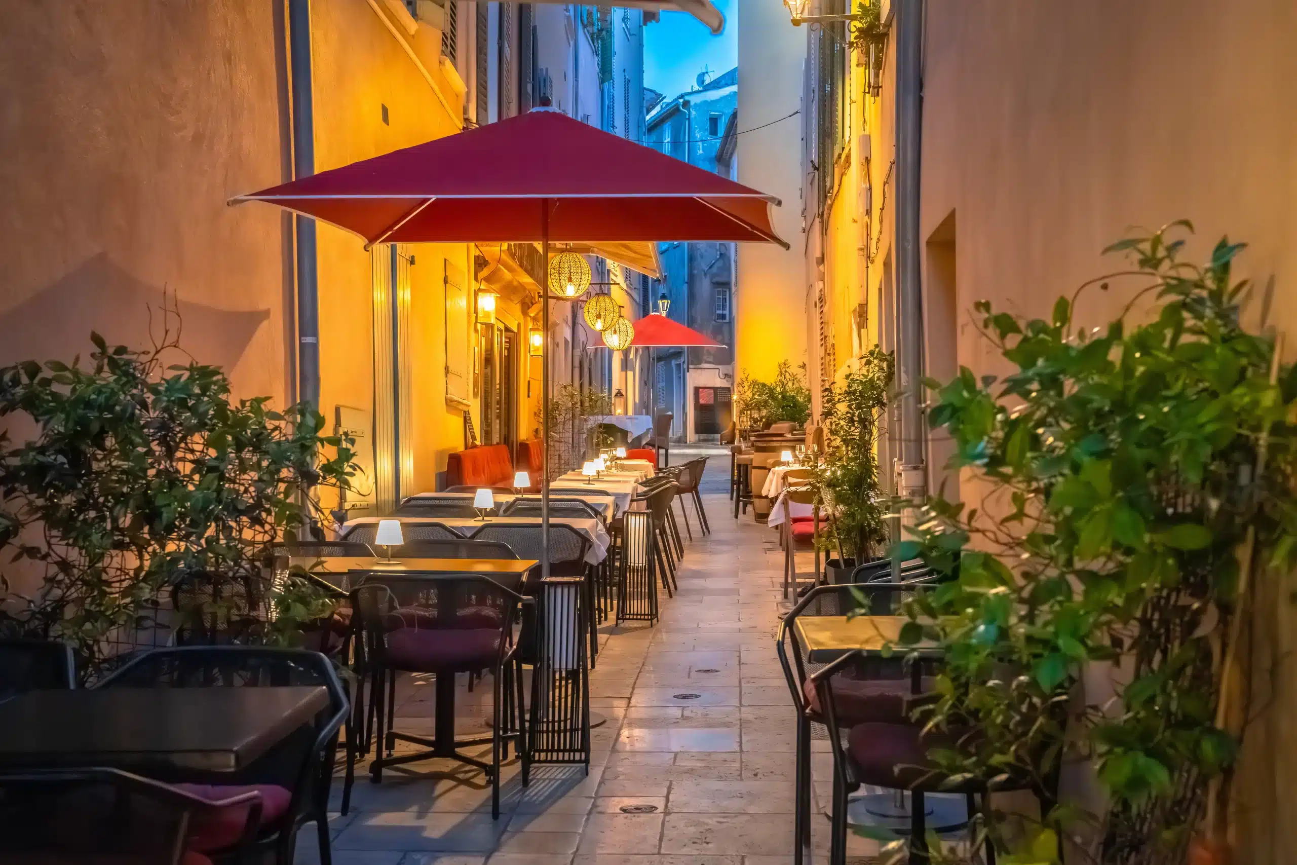 Terrasse de restaurant dans ruelle éclairée le soir