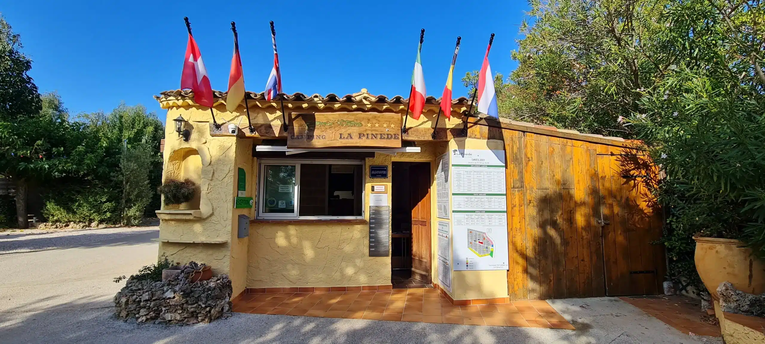 Entrée du camping La Pinède avec drapeaux